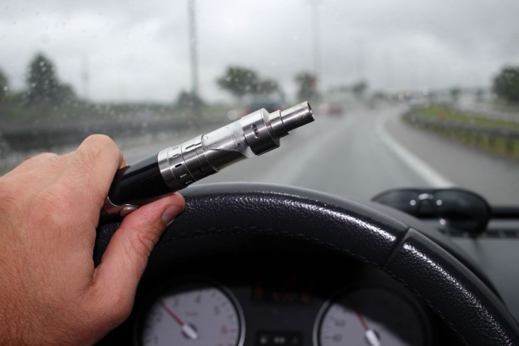 A driver vaping behind the wheel of a moving car