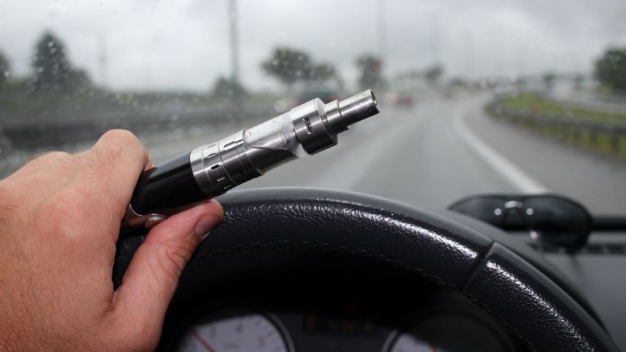 A driver vaping behind the wheel of a moving car