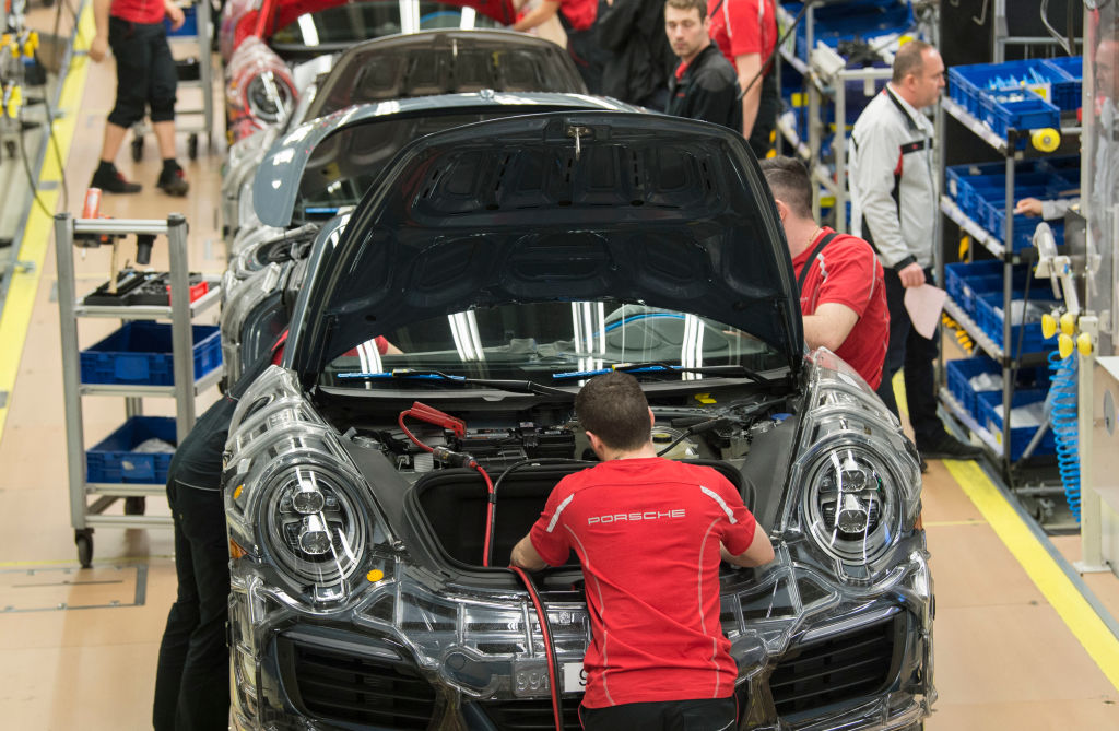 Porsche sportscars are lined up on the assembly line in the factory