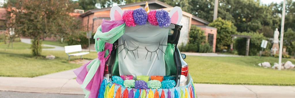 A colorful trunk-or-treat unicorn costume for a car.