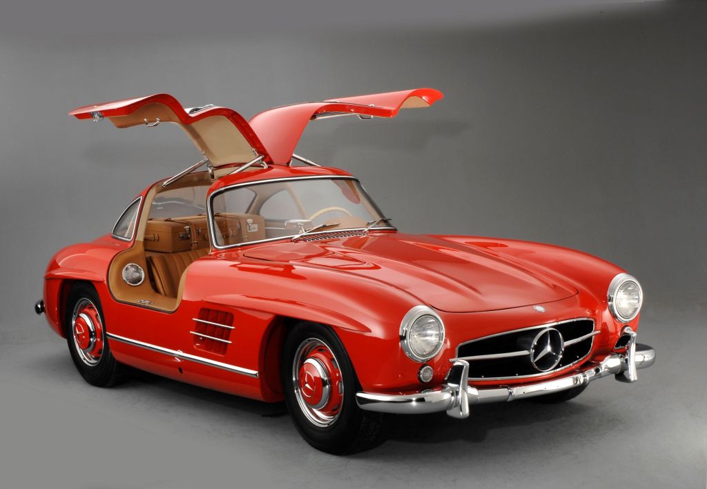A red 1957 Mercedes 300SL Gullwing coupe with its doors up