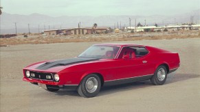 A red-and-black 1971 Ford Mustang Mach 1 on a desert runway