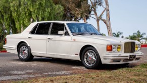 A white 1990 Bentley Turbo R with yellow headlights in a parking lot