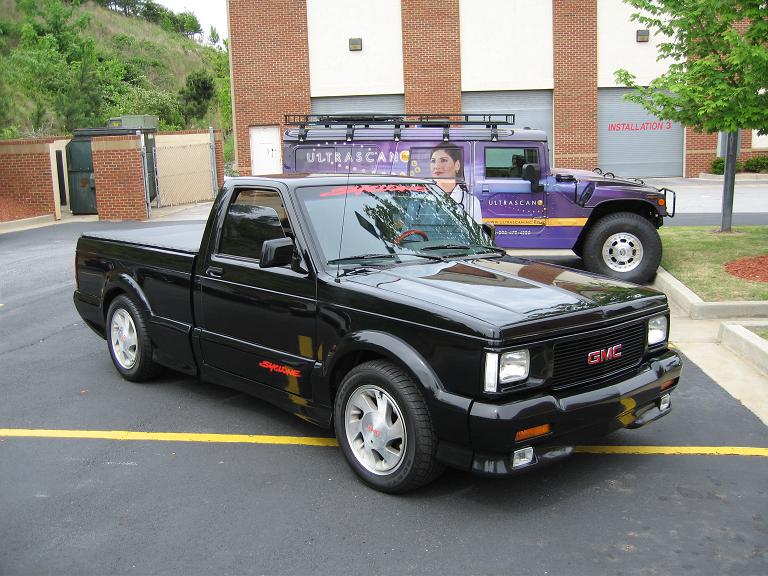 A black 1991 GMC Syclone parked in a parking lot