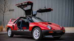 A red 1992 Autozam AZ-1 parked at right front angle with both gullwing doors open