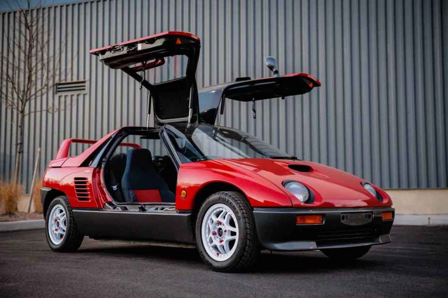 A red 1992 Autozam AZ-1 parked at right front angle with both gullwing doors open