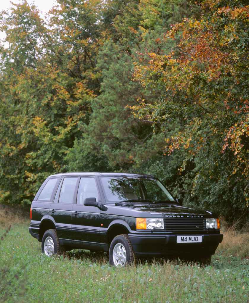 A black 1996 Range Rover parked near a forest, it's another step in the evolution of the Range Rover.