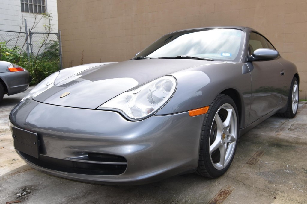 The front 3/4 view of a gray 2002 Porsche 911 Carrera in a parking lot