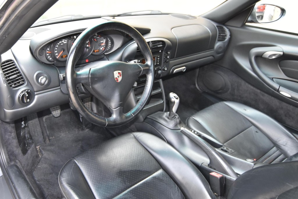 The black-leather front seats and dashboard of a 2002 Porsche 911 Carrera