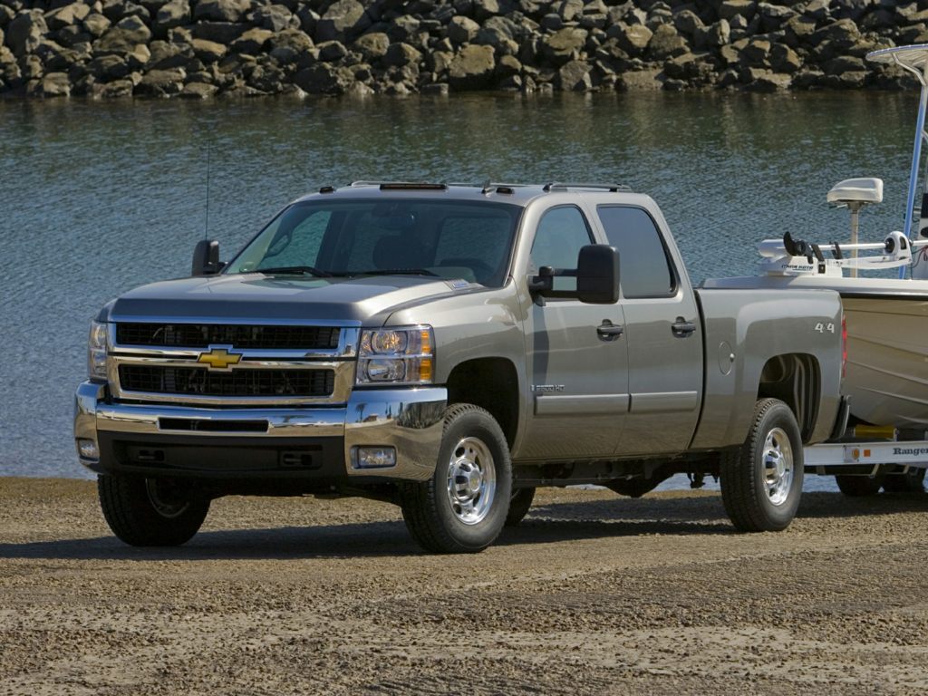 A gray 2009 Chevrolet Silverado 2500 HD pulls a boat out of the water