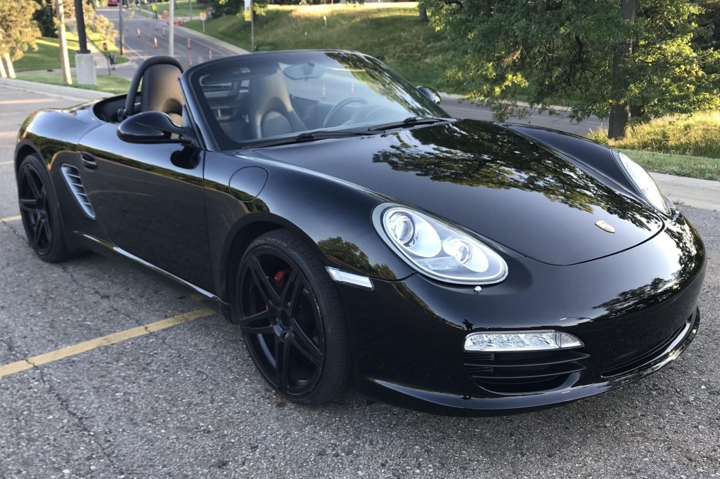 A black 2009 Porsche Boxster S parked in a lot on a hill