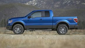 A blue 2012 Ford F-150 parked outside near grass