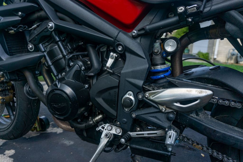 The adjustable rear mon-shock on a red-and-black 2012 Triumph Street Triple R
