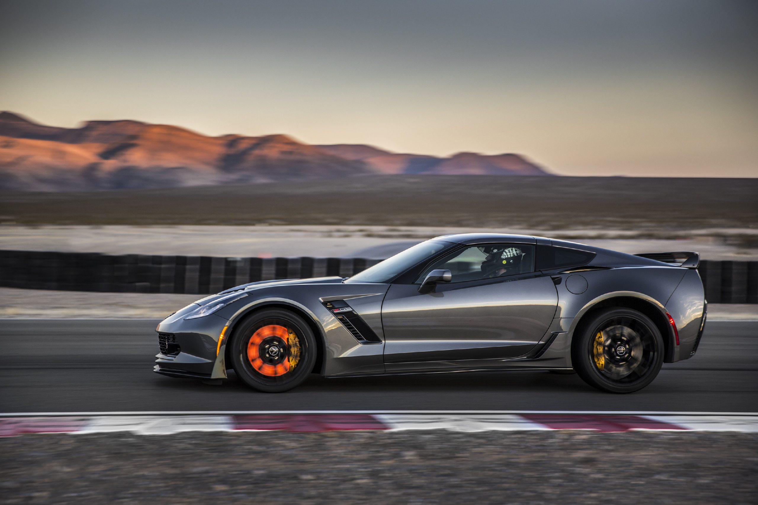 A grey 2019 Chevrolet Corvette Z06 shot in profile with rotors glowing under braking
