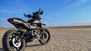 The rear 3/4 view of Trail Tech's gray 2019 Indian FTR 1200 S Adventure Custom in the desert