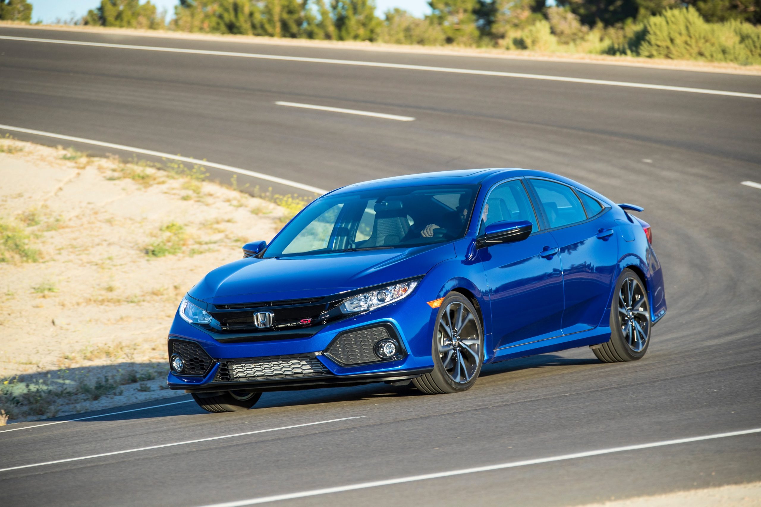 The 2019 Civic Si on a twisty road shot from the front 3/4