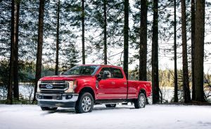 The 2020 Ford F-250 King Ranch F-Series Super Duty pickup truck in red parked in a snowy forest