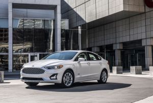 The 2020 Ford Fusion midsize sedan in white parked outside of an office building