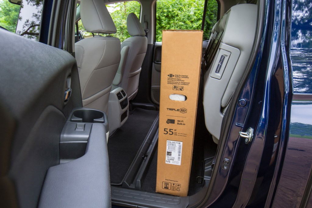 2021 Honda Ridgeline seat-bottom storage visual showing a 55-inch TV stored in the cabin.