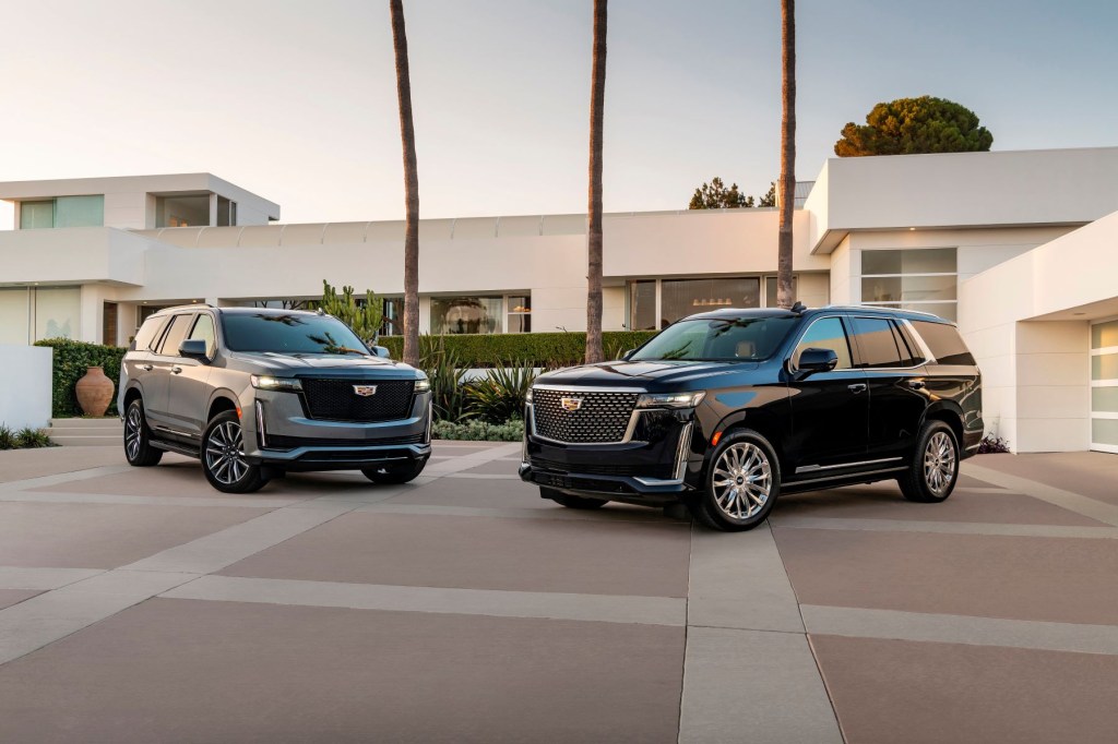 2021 Cadillac Escalade Premium Luxury and Sport luxury full-size SUV models parked outside of a luxury home