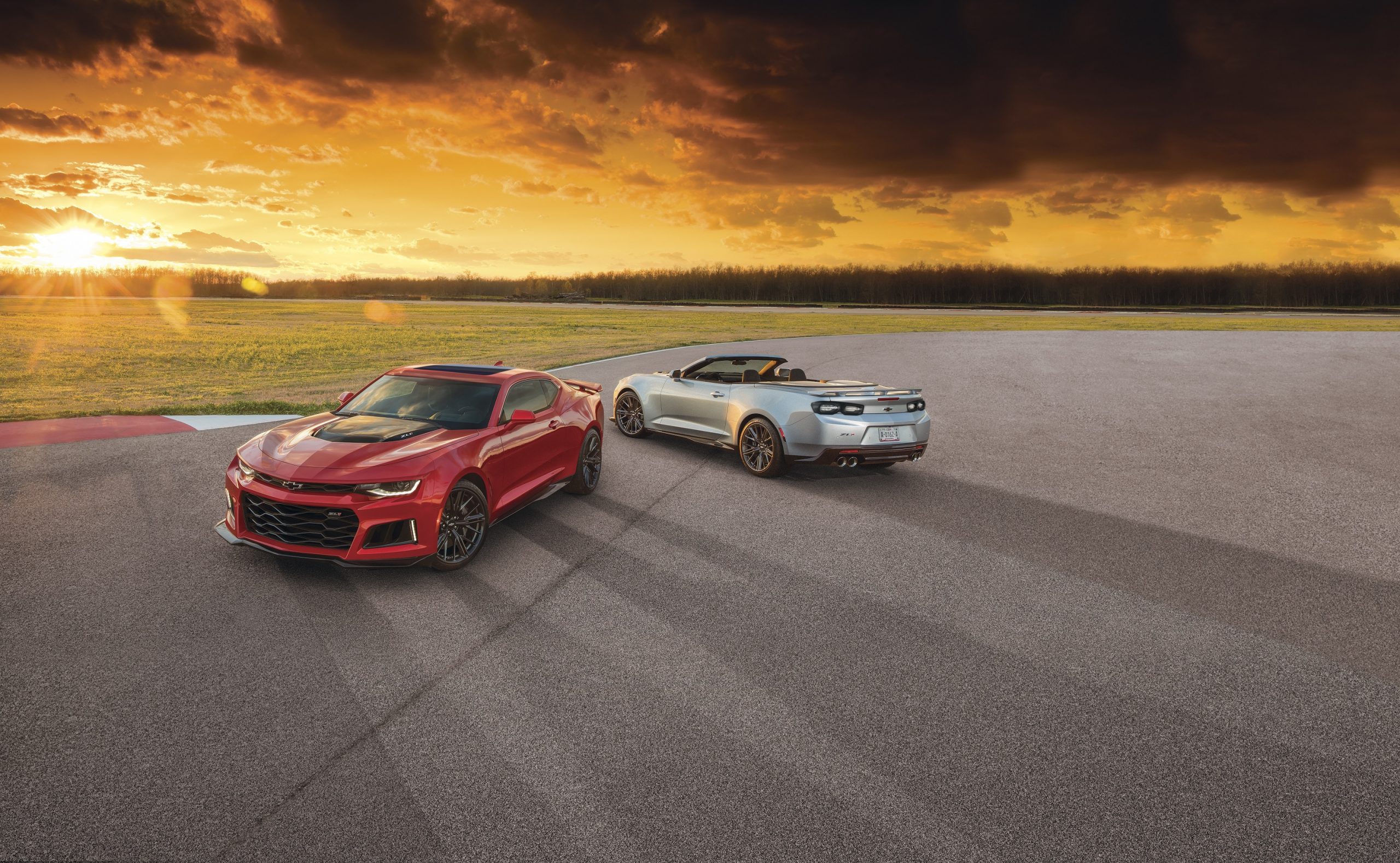 A red 2021 Chevrolet Camaro ZL1 coupe and convertible at sunset
