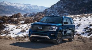 The 2021 Ford Expedition STX full-size SUV in dark blue parked on a snowy mountain trail