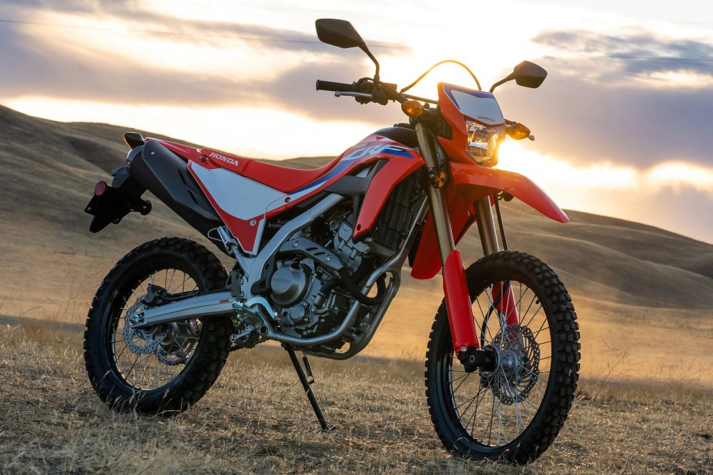 A red and white 2021 Honda CRF300L double sport motorcycle in the middle of the desert plains