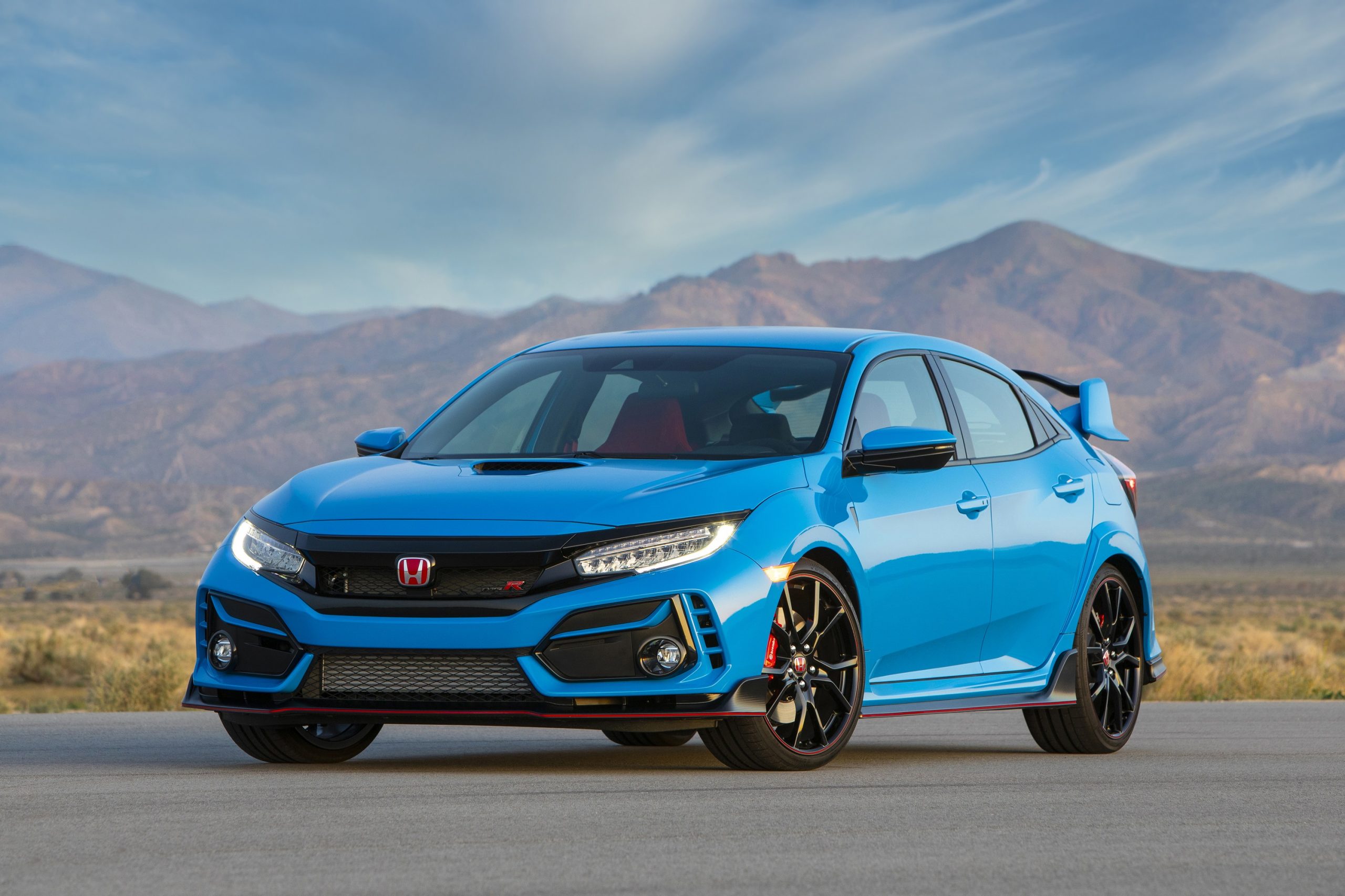 A blue Honda Civic Type R shot from the front 3/4 at sunset