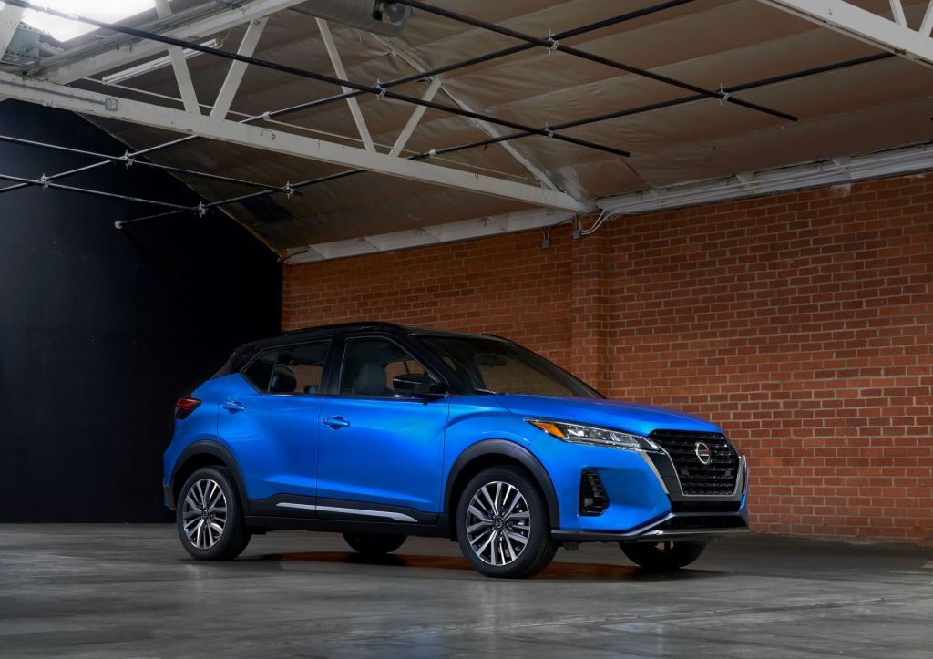 The 2021 Nissan Kicks subcompact SUV with a blue body and black roof parked in a brick warehouse