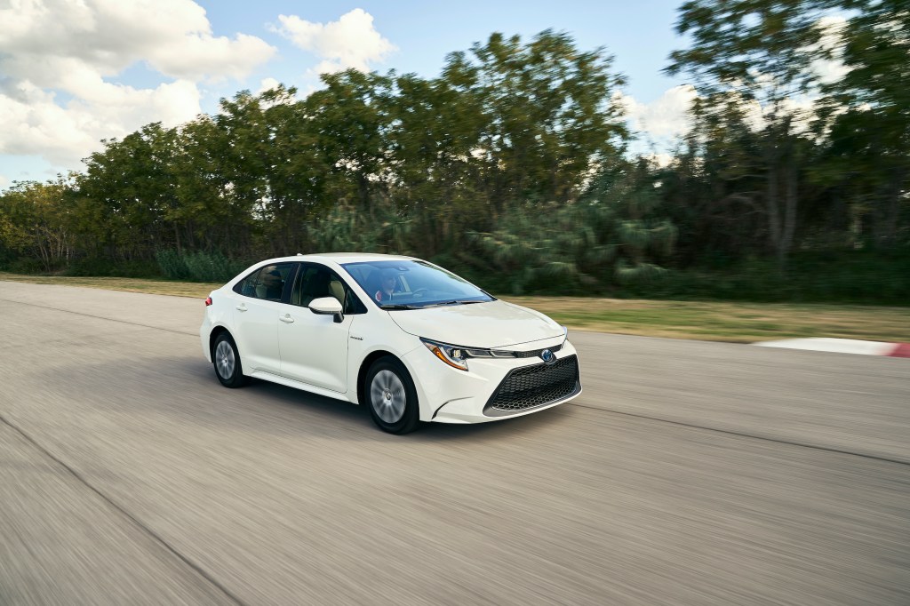 2021 Toyota Corolla Hybrid driving down a highway in white