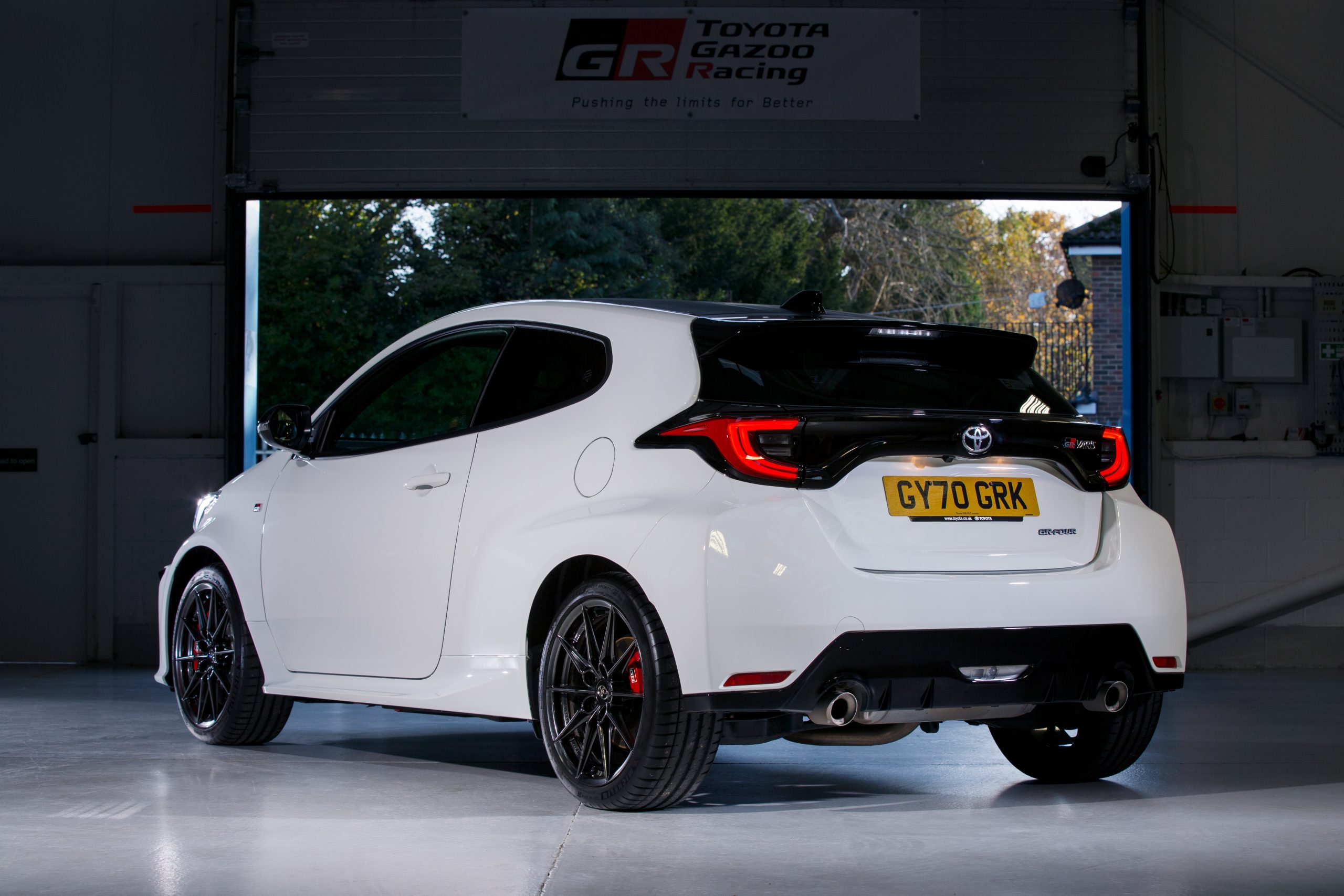 The rear 3/4 of a white Toyota GR Yaris in a garage