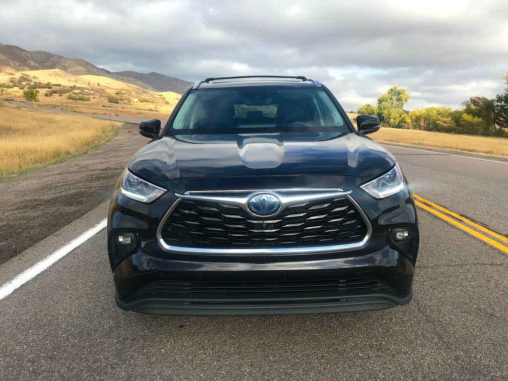 A front shot of the 2021 Toyota Highlander Hybrid on a mountain road