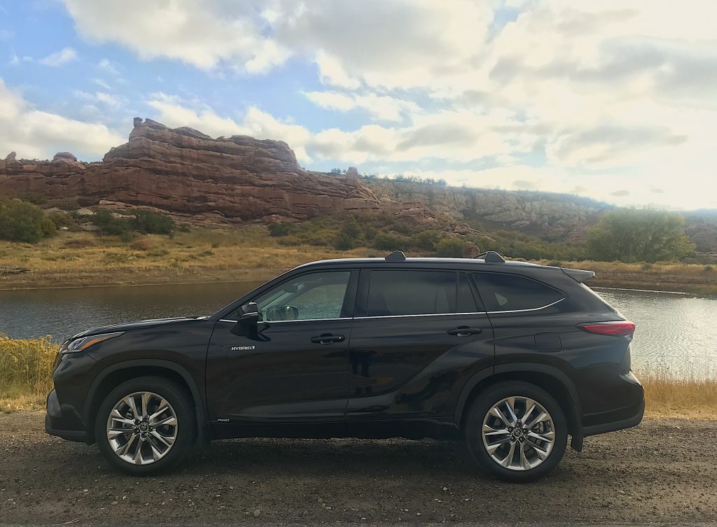 A side shot of the 2021 Toyota Highlander Hybrid next to a lake