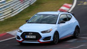 A pale blue Hyundai Veloster N lapping the Nurburgring shot from the front 3/4