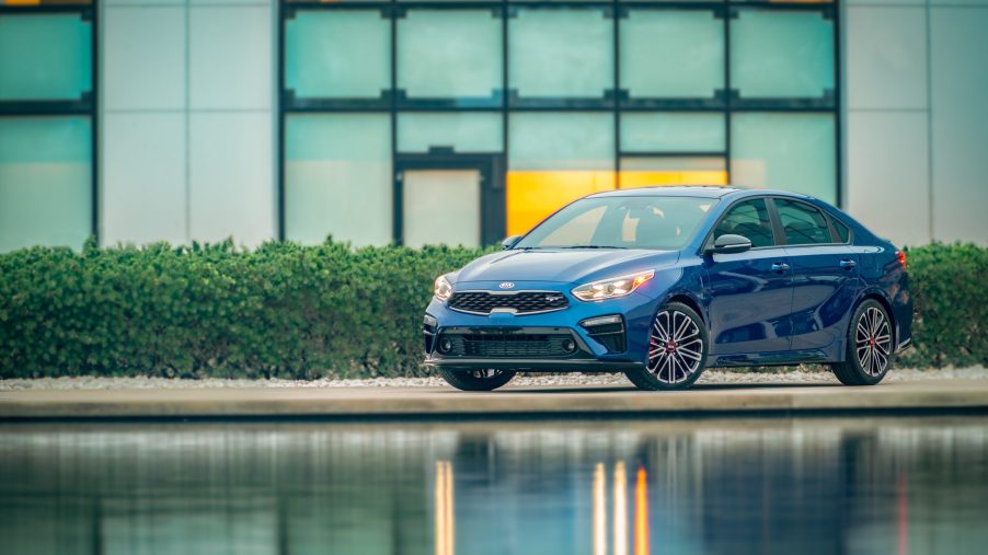 A blue 2021 Kia Forte GT shot in front of a pond from the front 3/4