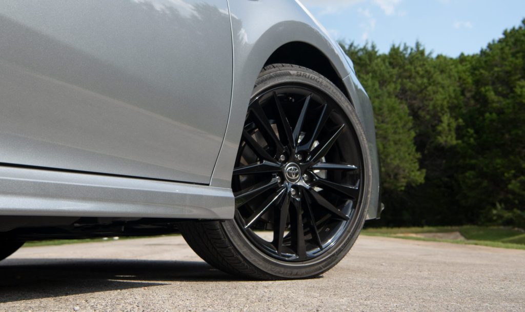 A close up shot of a 2021 Toyota Camry Hybrid XSE black 19-inch wheel