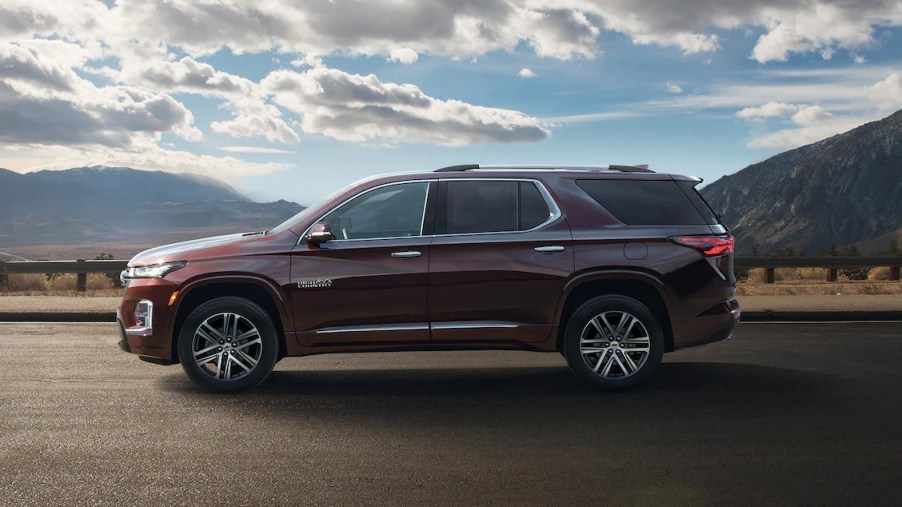 A maroon 2022 Chevy Traverse High Country is parked on the road, it received a few new features this model year.