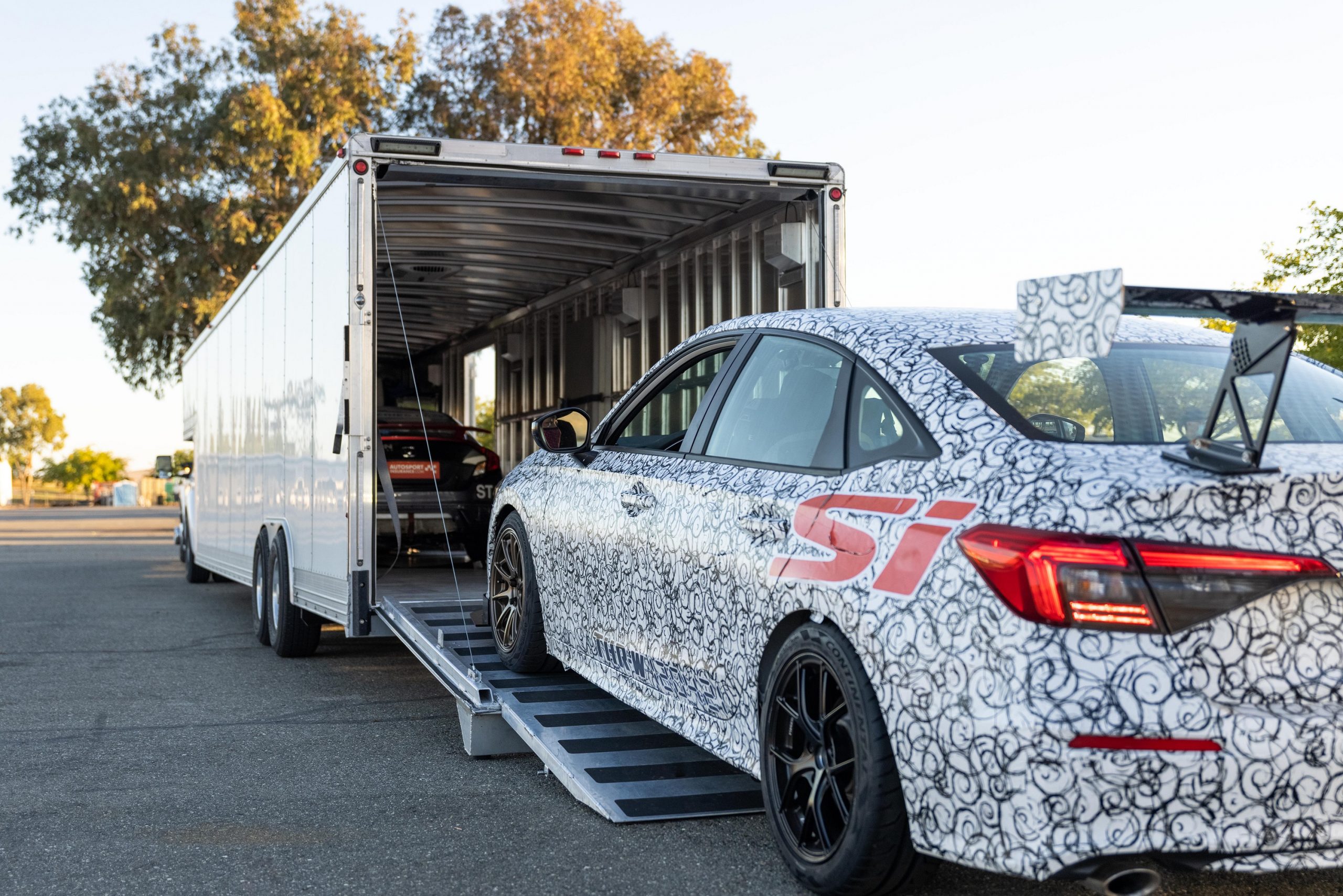 The race-spec Civic Si being loaded into a trailer, shot from the rear 3/4.