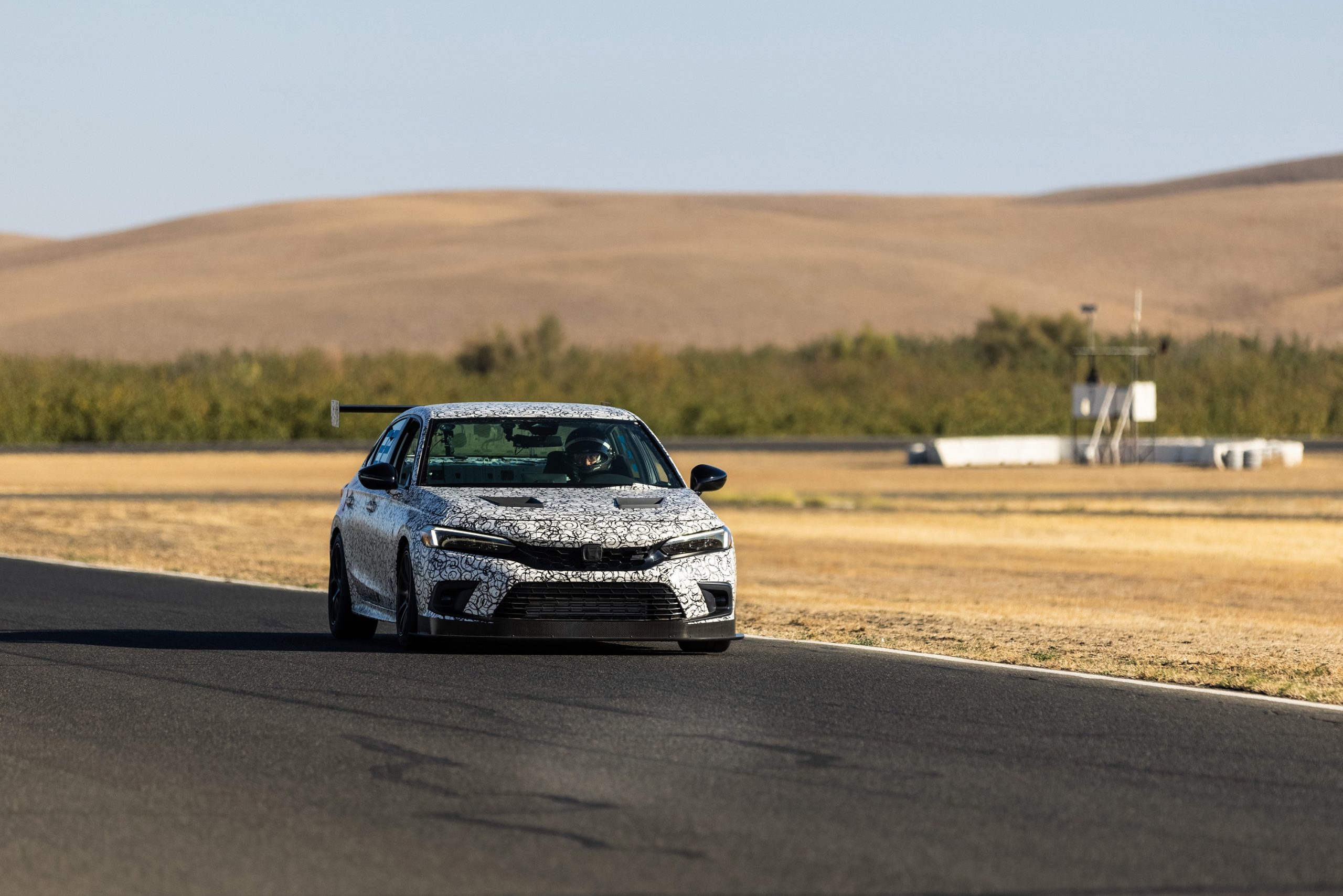 The camo-liveried 2022 Honda Civic Si during race testing shot from the front 3/4
