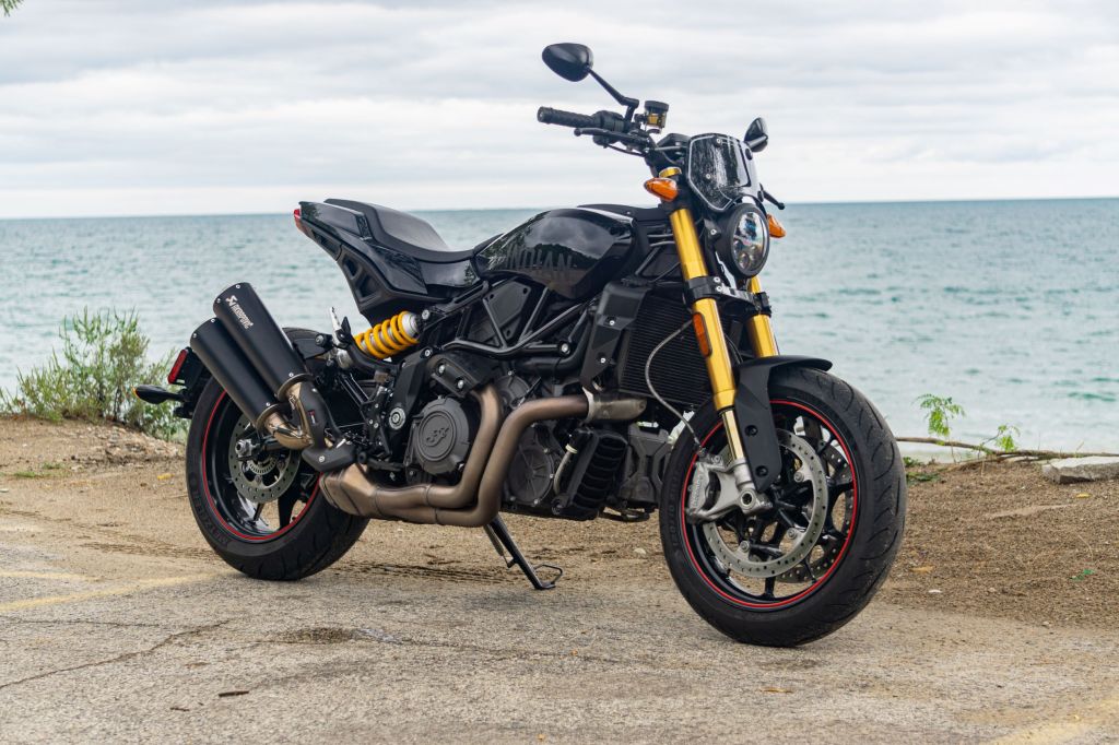 A black accessorized 2022 Indian FTR S parked by a Lake Michigan beach