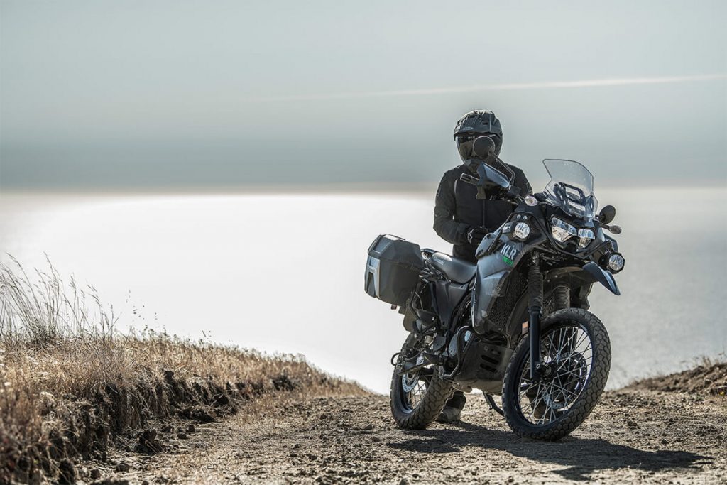 Is a dual sport motorcycle a street legal dirt bike? - MotorBiscuit 5 A black clad rider on a gray-camo 2022 Kawasaki KLR 650 Adventure dual sport motorcycle in the desert