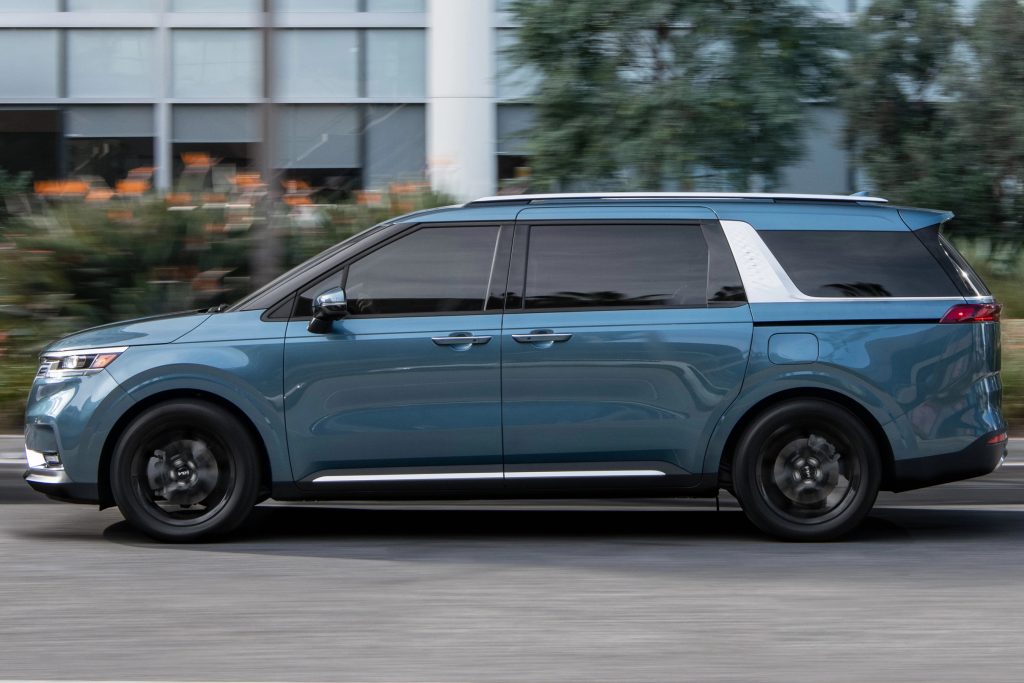 A blue 2022 Kia Carnival is parked on the side of a road
