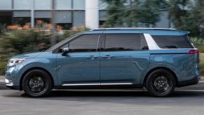 A blue 2022 Kia Carnival is parked on the side of a road. Could it be better than the 2022 Toyota Sienna?