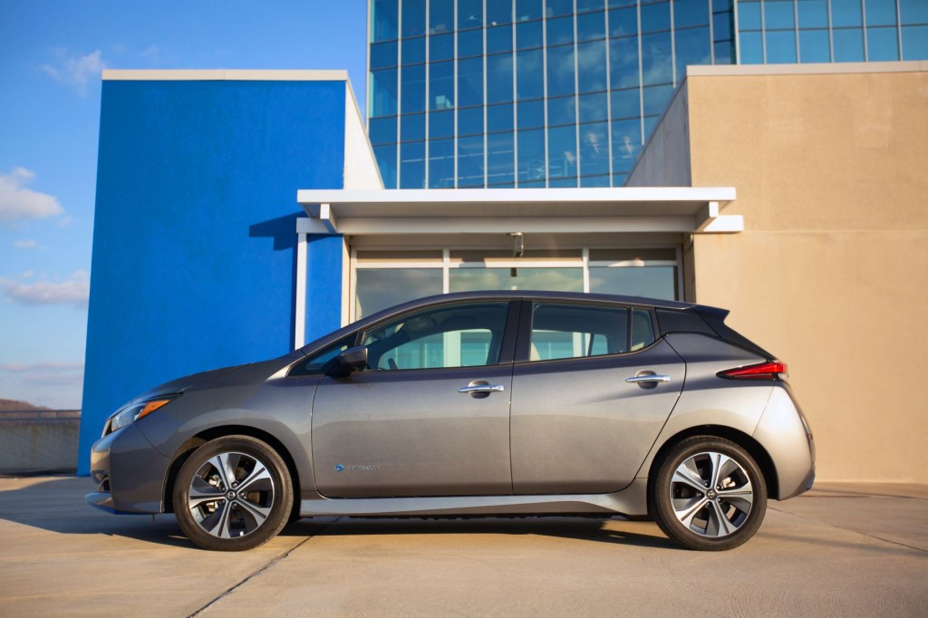 The 2022 Nissan Leaf electric hatchback vehicle exterior side shot parked outside of a glass building