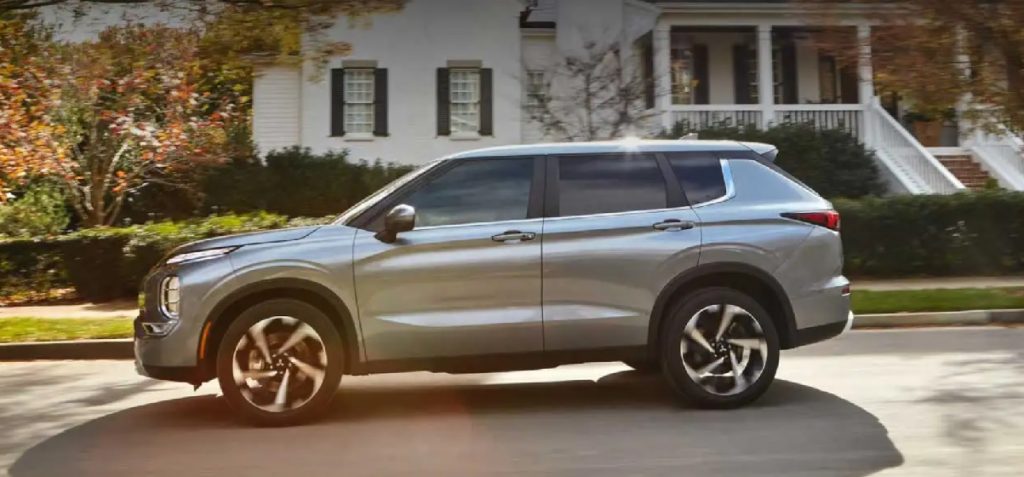 A silver 2022 Mitsubishi Outlander parked in front of a house.