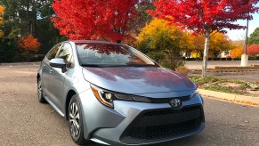 2022 Toyota Corolla Hybrid sitting next to colorful trees in a parking lot.