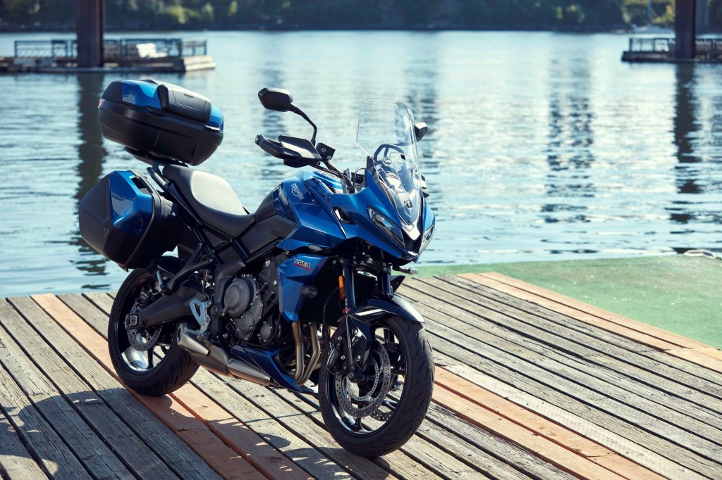 A blue-and-black 2022 Triumph Tiger Sport 660 with accessories by a river