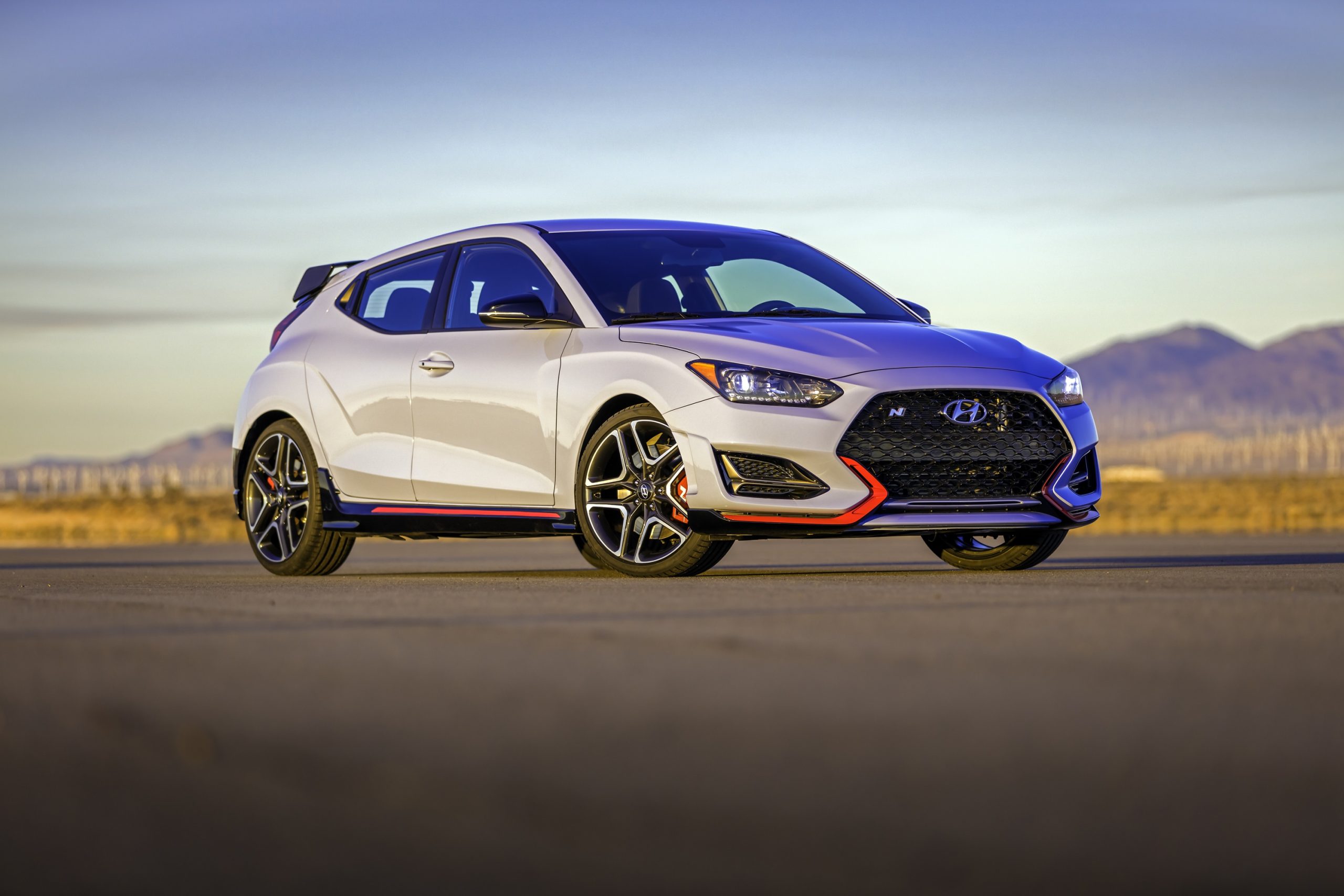A grey 2022 Hyundai Veloster N shot from the front 3/4 at sunset