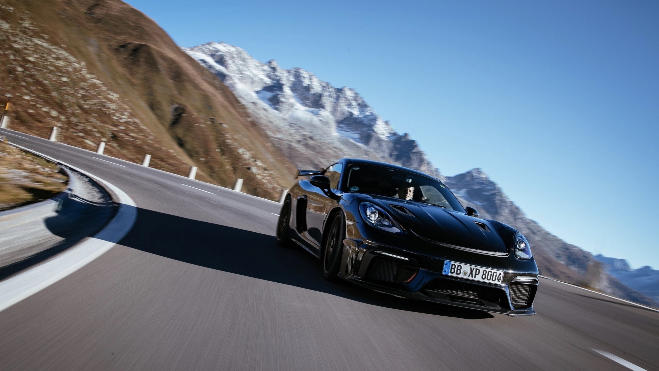 A black 2022 Porsche Cayman GT4 RS shot from the 3/4 angle on a mountain pass