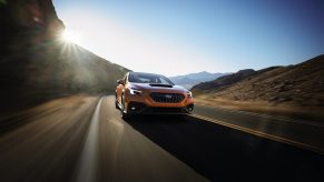 An orange 2022 Subaru WRX shot on a canyon road